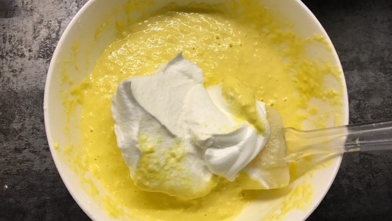 玉米蒸蛋糕,取1/3蛋白霜加入蛋黄糊中翻拌均匀