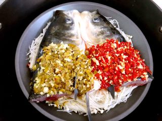 双色剁椒鱼头,腌制好把盘子放入蒸锅里，水开以后大火蒸15分钟关火，焖5分钟再打开盖子把鱼拿出来