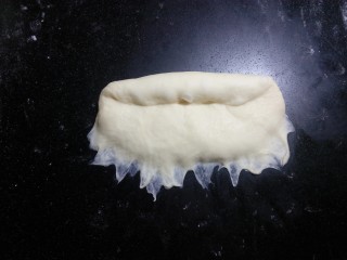 炼奶辫子面包,翻面后，压薄底边，自上而下卷起，中间尽量不要有空气.
