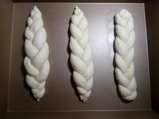 炼奶辫子面包,依次编好三根辫子。放入烤盘，整理好形状和位置，开始二次发酵。