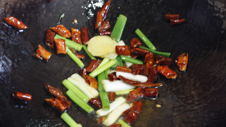 超快手的包菜炒粉丝,锅中倒入油，待油微热后加入葱姜红干椒翻炒爆香。