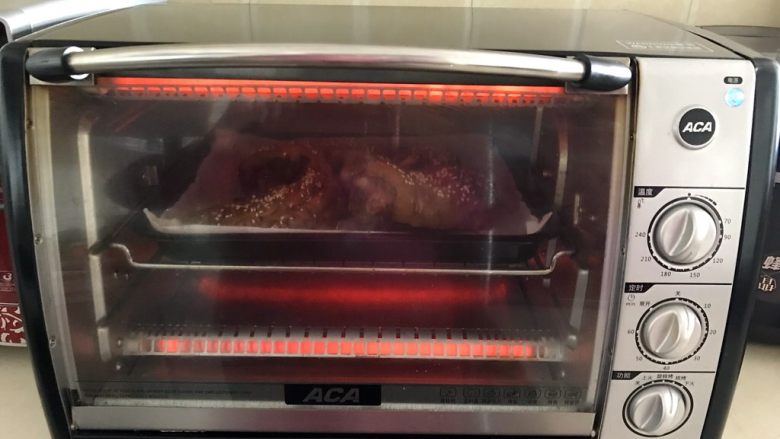 香辣烤猪手,把烤盘放入烤箱，上下火200W，烤8分钟即可