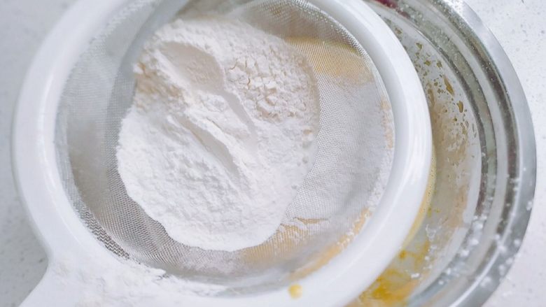 普通面粉版-戚风纸杯蛋糕,将普通面粉和所有的玉米淀粉合到一起，过筛到蛋黄里，留一半，搅拌到完全融合。