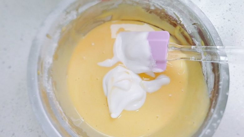 普通面粉版-戚风纸杯蛋糕,搅拌融合后，再加蛋白的一半到蛋黄里，接着同样的手法搅拌。