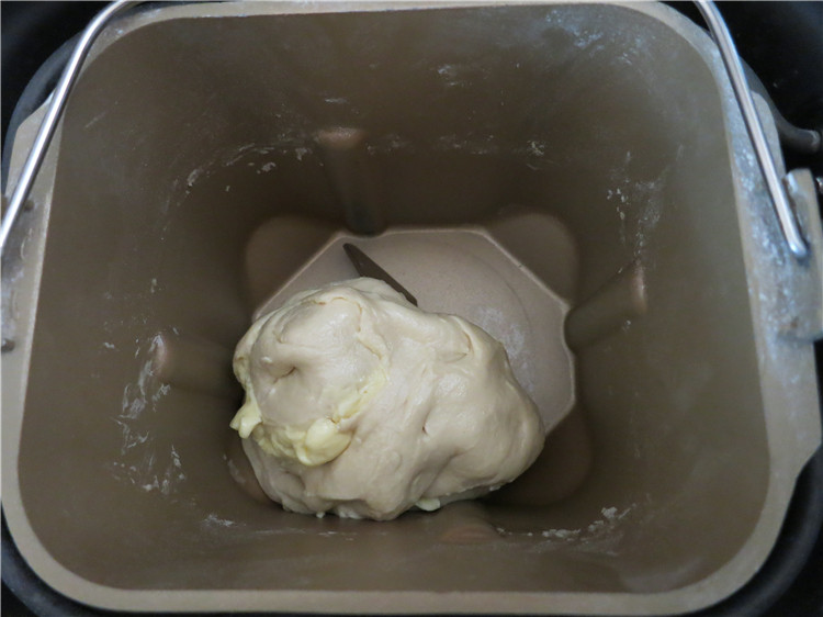 新网宠面包“白富美”净净包,搅打完成后，可以看到面团已经成型，这时候将软化后的黄油25克加入面团里继续搅拌