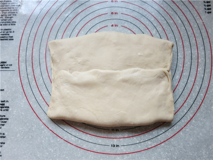 新网宠面包“白富美”净净包,两边的面片折过来，将面团的接缝处捏紧使黄油完全裹在面团里