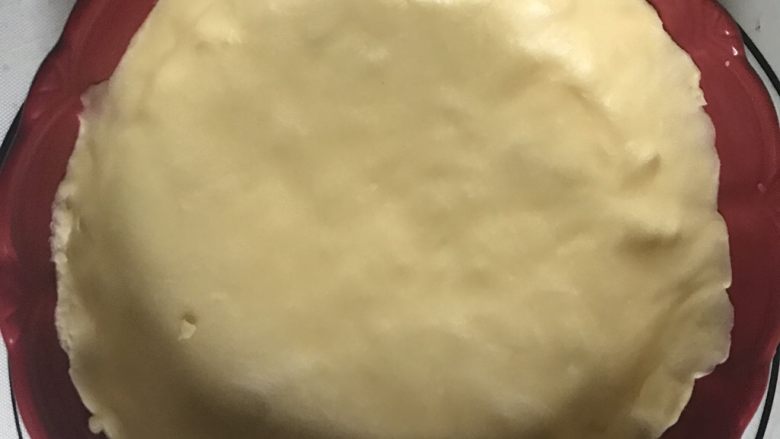 蛋奶香蕉派,取出松弛好的派皮，擀成饼状，铺在派盘上。用刀切除多余的边角