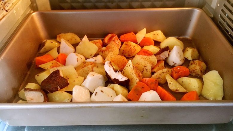 新奥尔良口味烤羊排,烤盘里放适量的土豆，胡萝卜，香菇，放入少许的油、少许的盐，少许的孜然粉和辣椒粉。