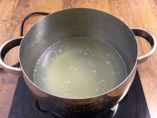 鸡汁小米海参粥,取800ml的鸡汤放入煮粥的小锅里。