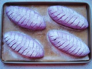 紫薯葡萄干欧包,发酵至稍微变大。用小筛子撒上薄薄的一层干面粉。用锋利的刀片割出喜欢的花纹。