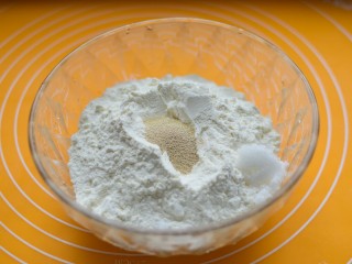 如意豆沙包,面粉、白糖、泡打粉放一起，中间挖一个小坑，放酵母