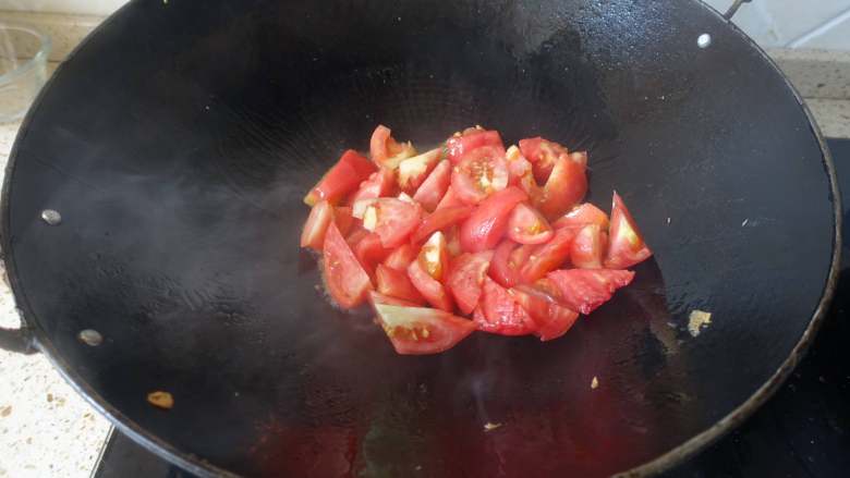 番茄炒鸡蛋,锅里放入少许植物油，烧至7成热。将番茄倒入锅里，大火翻炒。