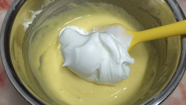 7寸中空戚风蛋糕,取三分之一蛋白放入蛋黄液中，用翻拌与切拌手法将两者混合均匀