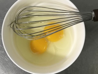 可可毛巾卷,将鸡蛋打入碗中，用打蛋器打散。
