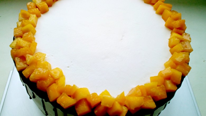 芒果淋面生日蛋糕,然后在边缘摆上芒果丁。