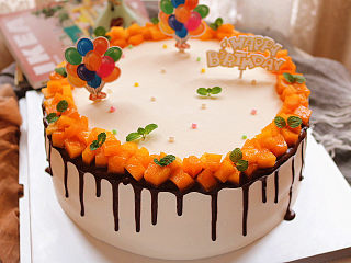 芒果淋面生日蛋糕,最后用糖珠和插牌装饰即可。
