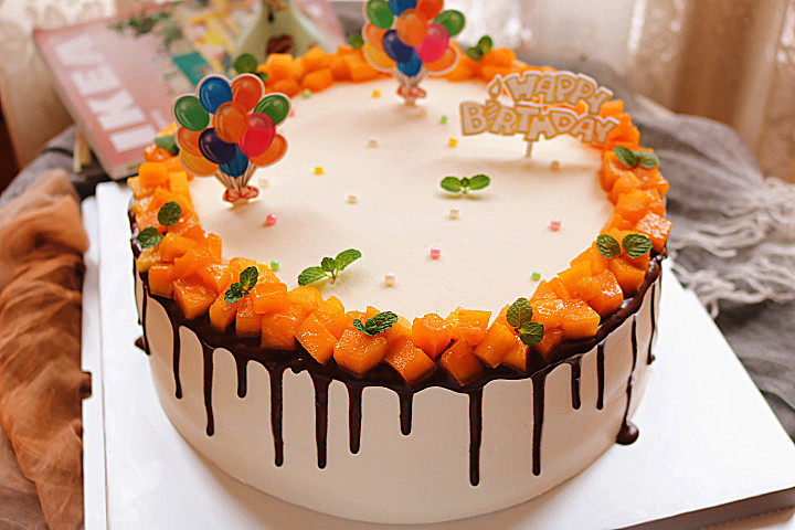 芒果淋面生日蛋糕,最后用糖珠和插牌装饰即可。