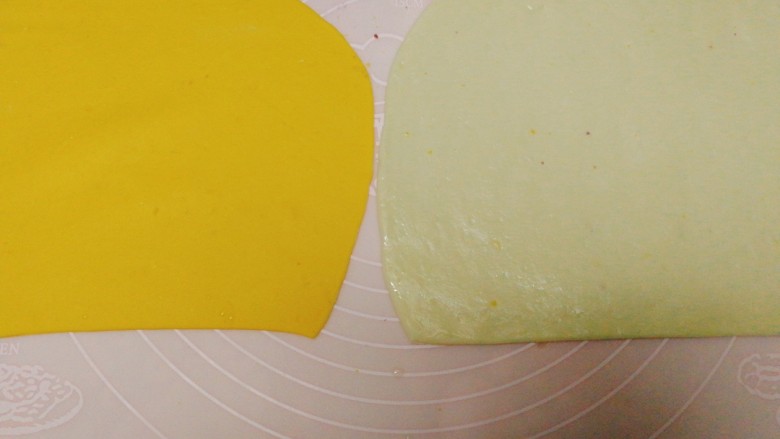 双色南瓜花卷,将两种面团擀成面皮备用，在一张面皮上刷一层油。