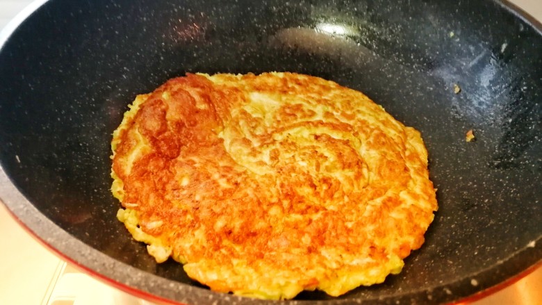 快手早餐&香芹小虾米鸡蛋饼,翻个（会颠勺的很简单就能颠过来，不会颠勺的可以把一个盘子倒扣在鸡蛋饼上，把锅翻过来也可以）。