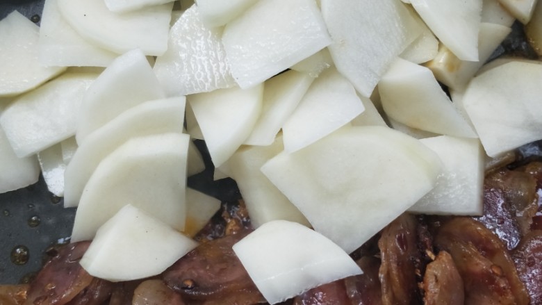 酱香土豆炒腊肠,把腊肠拨到锅边一点，倒入沥干水的土豆片。