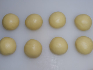 椰蓉小面包,将面团平均分成8份，滚圆盖上保鲜膜松弛15分钟。
松弛时间取出椰蓉馅，也平均分成8份搓成圆球。