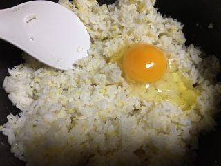 黄瓜火腿肠蛋炒饭,先打1个鸡蛋到隔夜饭中，搅拌均匀