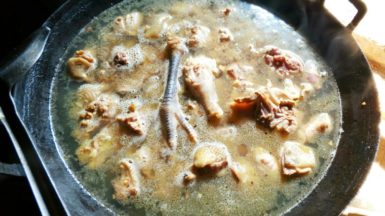 铁锅糊米鸡,加入清水，没过鸡肉为好。加柴煮开。