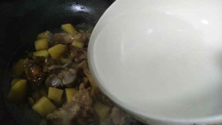 猪脚炖土豆,翻炒均匀后加入适量的水。