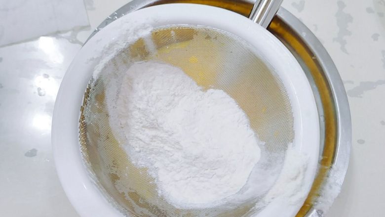 普通面粉版-原味戚风蛋糕卷,筛入一半的面粉混合物，搅拌均匀。