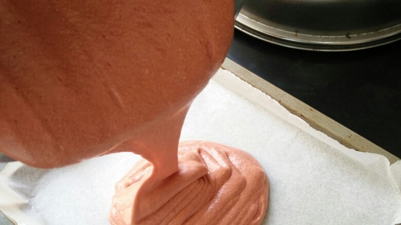 红丝绒蛋糕卷,把蛋糕糊倒进烤盘里，用刮刀刮平。