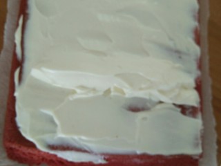红丝绒蛋糕卷,然后把奶油抹在蛋糕上，卷起来，放冰箱冷藏一个小时定型。