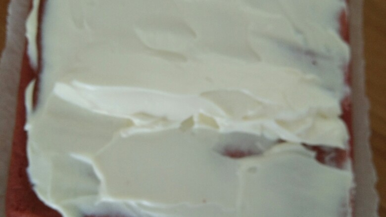 红丝绒蛋糕卷,然后把奶油抹在蛋糕上，卷起来，放冰箱冷藏一个小时定型。