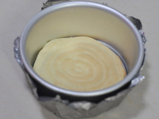 舒芙蕾芝士蛋糕,将海绵蛋糕底铺在6英寸的圆模内，蛋糕模外用锡纸包上