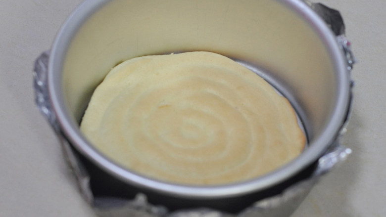 舒芙蕾芝士蛋糕,将海绵蛋糕底铺在6英寸的圆模内，蛋糕模外用锡纸包上