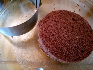 草莓奶酪慕斯蛋糕,将其中一块用4寸慕斯模切出一块圆形备用。在六寸活底蛋糕模底部摆上六寸蛋糕片。