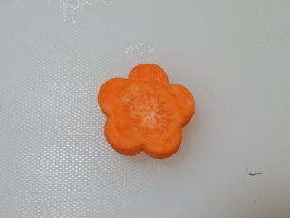 宝宝辅食—翡翠肉松菜饭,取一片胡萝卜片用模具压出花形。