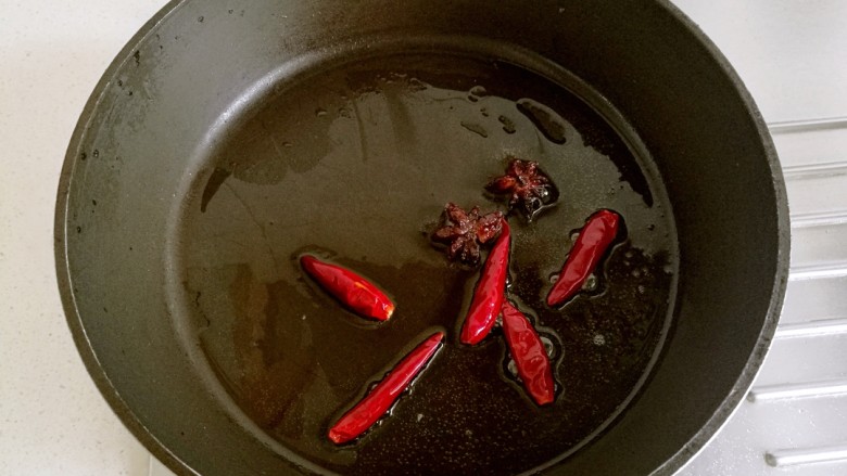 红烧豆腐角,炒锅里放适量油，放入大料和干辣椒略炸出香味。