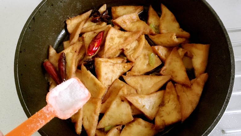 红烧豆腐角,等到汤汁收浓稠时，加入适量的盐。