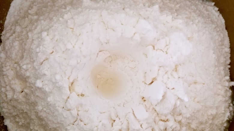 马斯卡彭炼奶双色土司,加入面粉，中间挖一个洞