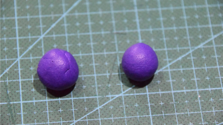 凹造型的独角兽玛琳糖,将紫色的翻糖膏取出4g左右。并等分成两团。