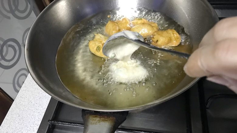 炸面团子,将面糊一股脑的在同一个位置，不要移动勺子，倒入油锅里。