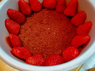草莓奶酪慕斯蛋糕,牛奶草莓用淡盐水洗净，切去底部，将一半草莓对半切开，在第一层蛋糕上摆上草莓。