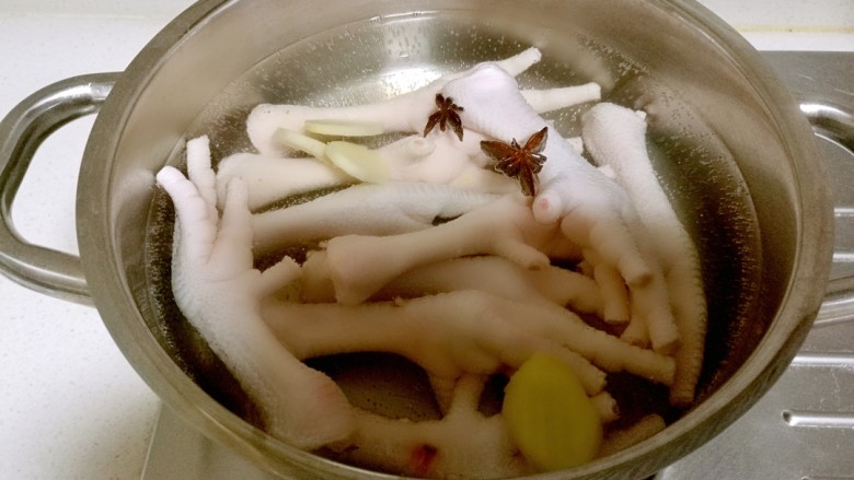 韩式辣酱鸡爪,锅中放入凉水，放入鸡爪加入一个八角，几片姜片。