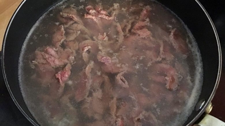 沙茶牛肉粉丝煲,腌好的牛肉逐片放入滚水中变色捞起备用