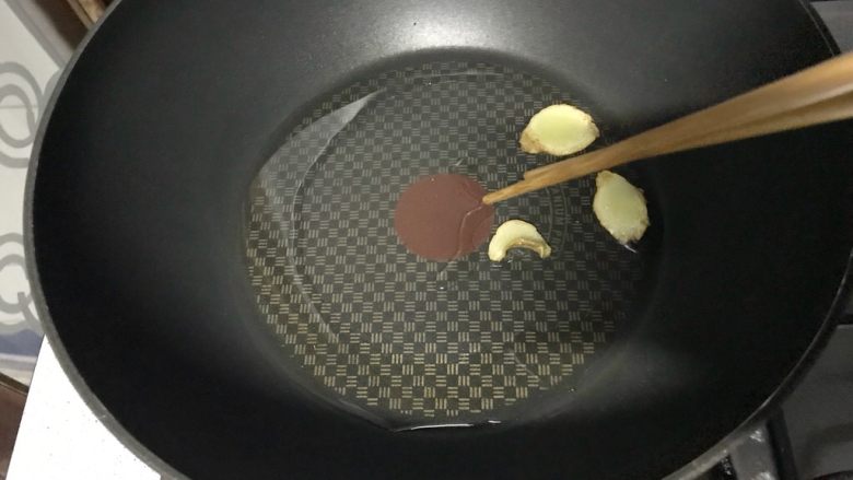 家常小炒韭菜香干,用筷子把炸过的姜片捡出来。