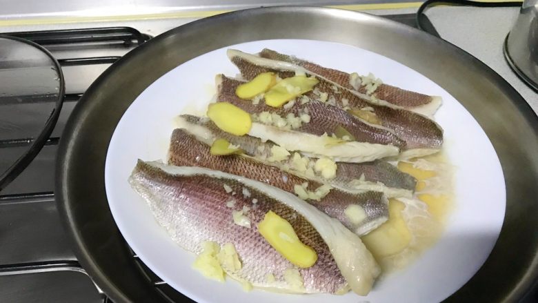 馋嘴版家庭烤鱼,蒸好的鱼，把姜片取下来，汤可以倒掉。