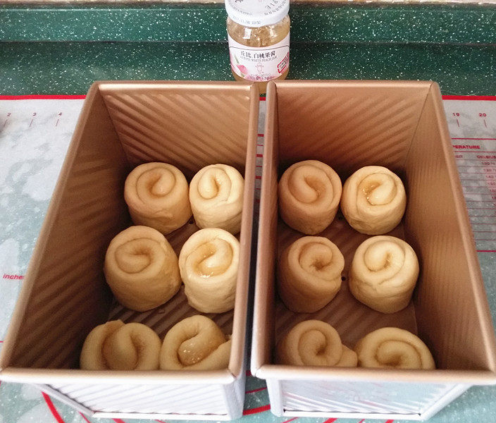#花样吐司#白桃果酱吐司卷,依次放入吐司盒中、送至烤箱开启发酵功能