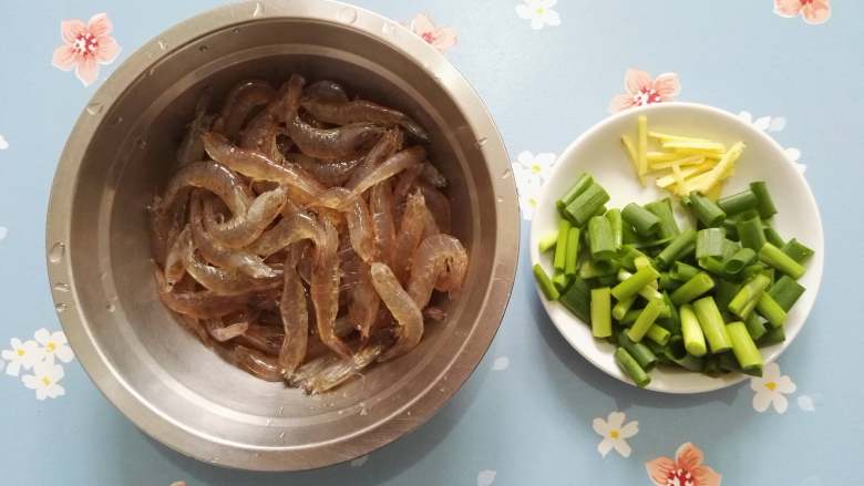 香炒河虾,虾洗净，剪去须和虾头部的尖刺，这样吃的时候就不会被扎到了，香葱切段，姜切丝。

