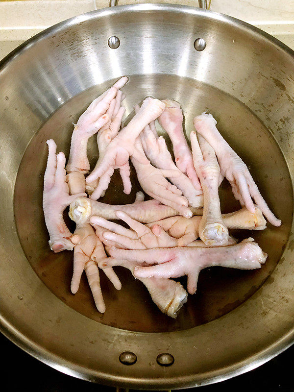 秘制红烧鸡爪,冲洗干净以后放入锅中，加入三碗水