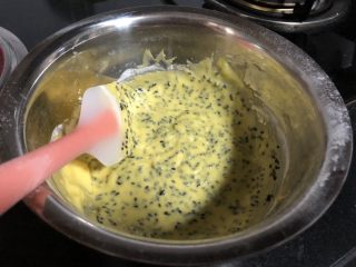 无麸质芝麻米粉戚风,取三分之一蛋白，加入蛋黄糊中，用刮刀拌匀。